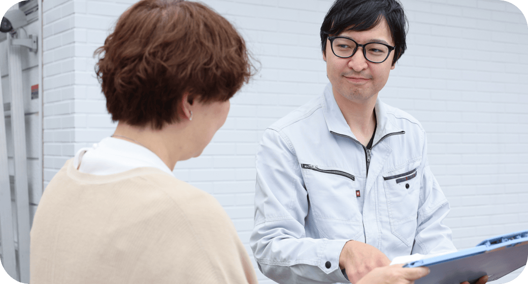 お客様宅前で検査の相談しているシーン