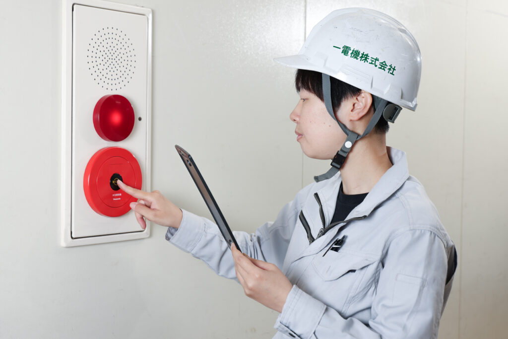 消防設備点検で防災設備を確認する点検員